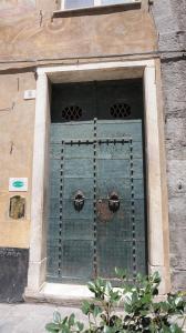 热那亚Le coccole的建筑中一扇带绿门的窗户