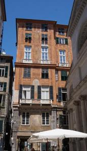 热那亚Le coccole的一座高大的砖砌建筑,设有窗户和雨伞
