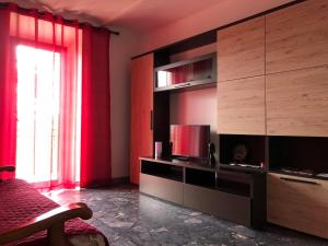皮蒂利亚诺La Casa del Villanu的客厅配有电视和红色窗帘