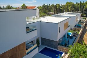 诺瓦利娅Novalja Bay Villas的享有白色建筑空中美景,设有游泳池