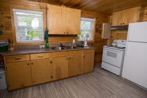 北拉斯蒂科北鲁斯蒂科度假村的厨房配有木制橱柜和白色冰箱。