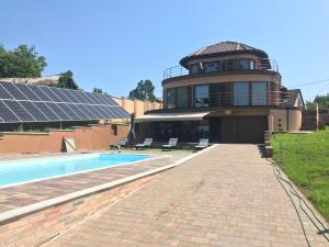 凯斯特海伊Royal Villa Keszthely的一座带游泳池的建筑和一座带太阳能电池板的建筑