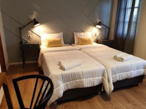 塞尔马Aigaion Guesthouse的一间卧室配有一张带白色床单和黄色枕头的大床。