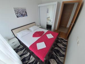 拉法洛维奇AS Apartments Rafailovici的一间卧室配有一张床铺,床上铺有红色毯子