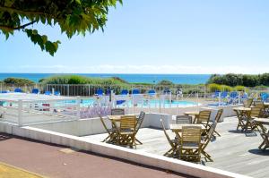 莱萨布勒-多洛讷Appartements front de Mer SABLES D'OLONNE的一个带椅子的甲板和一个游泳池,享有海景
