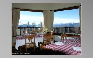 DumenzaRifugio Campiglio的一间设有两张桌子的山景用餐室