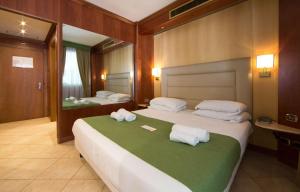 圣托·斯特凡诺·阿尔马尔红掌最佳西方酒店的酒店客房,配有两张带毛巾的床