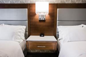 卡尔加里Holiday Inn Hotel & Suites Calgary South - Conference Ctr, an IHG Hotel的一间设有两张床的房间,中间设有床头柜