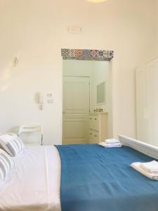 Giuggianello乐菲印度旅馆的一间卧室配有一张带蓝色毯子的大床