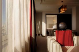 伦敦铂尔曼伦敦圣潘克拉斯酒店的一间配有沙发的房间和一个带卧室的窗户