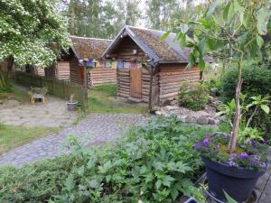 HartauBirkenhof Ashram Familien Blockhütten的花园的后面设有小木屋