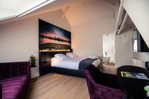 贝灵恩Boetiekhotel Burgemeesterhuys的一间卧室配有一张床和一张紫色沙发