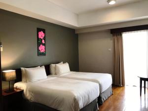 士姑来Pulai Springs Resort Official的酒店客房设有两张床和窗户。