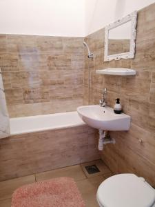 米什科尔茨Kriston Apartman的浴室配有盥洗盆、卫生间和浴缸。