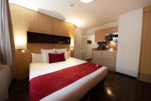 克莱蒙费朗普利罗吉斯卡雷德宫殿公寓酒店的卧室配有一张大白色床和红色毯子