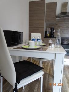 布雷斯地区布尔格Legend- Parking privé Gratuit- Terrasse privée- Wifi - Convert - Alimentec的白色厨房桌子、椅子和水瓶