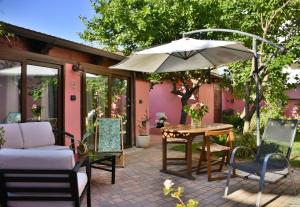 阿尔盖罗花卉别墅旅馆的庭院配有遮阳伞和桌椅。