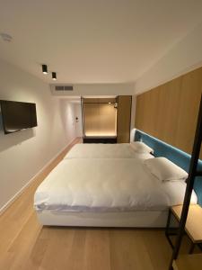 鲁瑟拉勒Parkhotel Roeselare的卧室配有一张白色大床和电视。