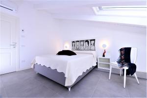 阿马尔菲Zia Pupetta Suites的白色卧室配有床和椅子