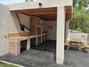 Cadalso de los VidriosCasa Rural Mirando a Gredos的一个带砖炉和木屋顶的庭院