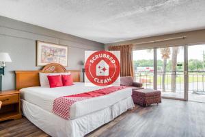 银泉OYO Hotel Mustang Silver Spring FL的酒店客房的床铺上标有红色的标志