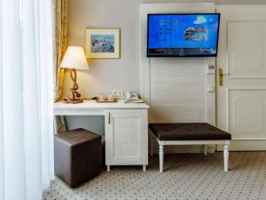 维斯普雷姆美第奇别墅及餐饮酒店的客房设有书桌和墙上的电视
