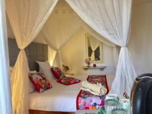 迈来亚Hotel Djerba Orient的卧室配有带枕头的天蓬床