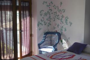 蒙地卡罗埃尔莫利诺德尔阿布罗的卧室配有一张床和一把椅子,靠窗