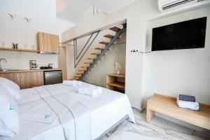 斯塔夫罗斯Alos Utopia的卧室配有白色的床和楼梯。