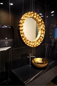 马马亚Stavros Hotel的浴室设有金色水槽和镜子