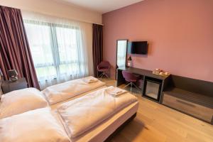 贾尔A22 Hotel Gyál的酒店客房设有两张床和电视。