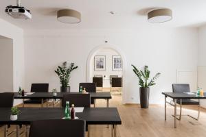 格拉茨玛丽亚希尔费酒店的用餐室配有桌椅和植物