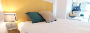 圣若瑟Le Tijo的卧室配有白色床和绿色枕头