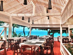 查汶Sans Souci Samui - SHA Plus的一间设有桌椅的海洋餐厅
