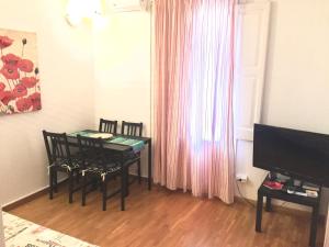 巴塞罗那阿普图卡特公寓的一间带桌椅和电视的用餐室
