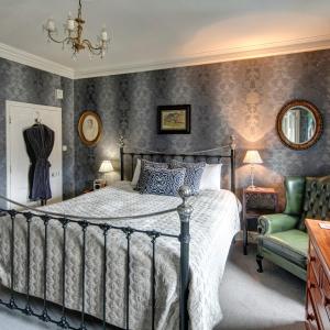 彻奇斯特雷顿Victoria House的一间卧室配有一张床和一把绿色椅子