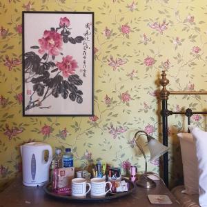 彻奇斯特雷顿Victoria House的一间卧室,配有一张桌子、杯子和一张鲜花