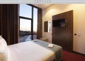 巴统Legend Business Hotel Batumi的酒店客房设有一张床和一个大窗户
