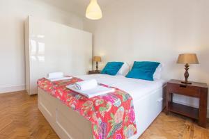 里斯本Saldanha Concept by Homing的一间卧室配有白色床和蓝色枕头