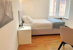 苏黎世Guesthouse Lochergut的一间白色的小卧室,配有一张床和一张桌子