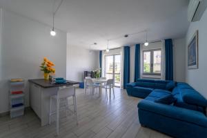 福洛尼卡La Luna nel Golfo - Appartamenti a Follonica的客厅配有蓝色的沙发和桌子