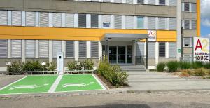梅明根A2 Boarding House Memmingen的前面有一座绿色篮球场的建筑