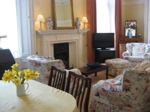 格拉斯哥纽荷尔酒店的客厅配有桌椅和壁炉