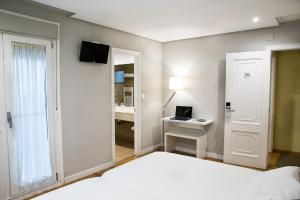 钱塔达莫伽依酒店的一间卧室配有一张床和一张带笔记本电脑的书桌
