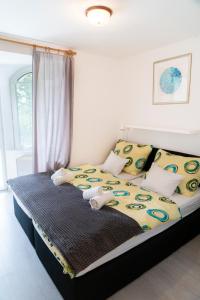 巴拉顿菲赖德Kék Hullám Vendégház的一间卧室配有黄色和蓝色枕头的床