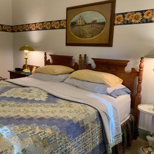 尤宁敦Watson Estate BnB & Deer Creek Winery的卧室配有一张大床,墙上挂着一张照片
