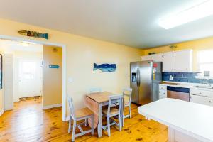多芬岛Two Views的厨房配有桌椅和冰箱。