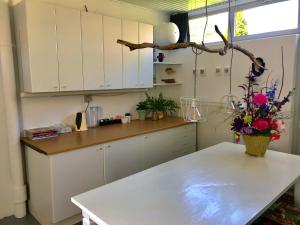 芬莱De Vlies的厨房配有白色橱柜和鲜花桌