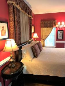 威廉斯堡威廉斯堡白宫酒店 的一间卧室设有一张红色墙壁和窗户的床