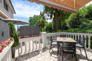 奥帕提亚Apartments Villa Salona的白色围栏上带桌椅的庭院